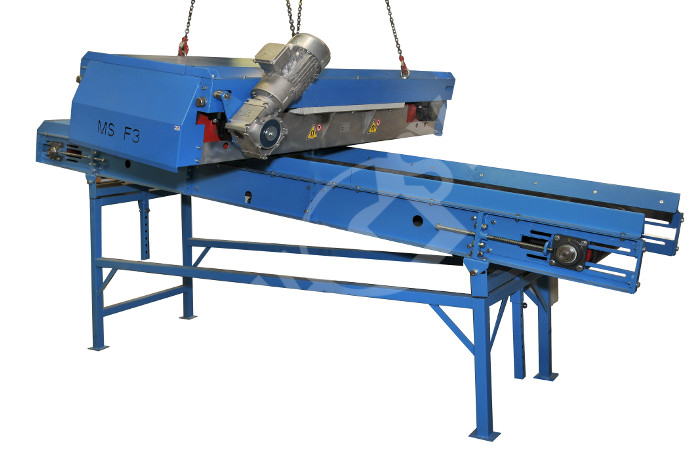 Self-cleaning magnet above conveyor